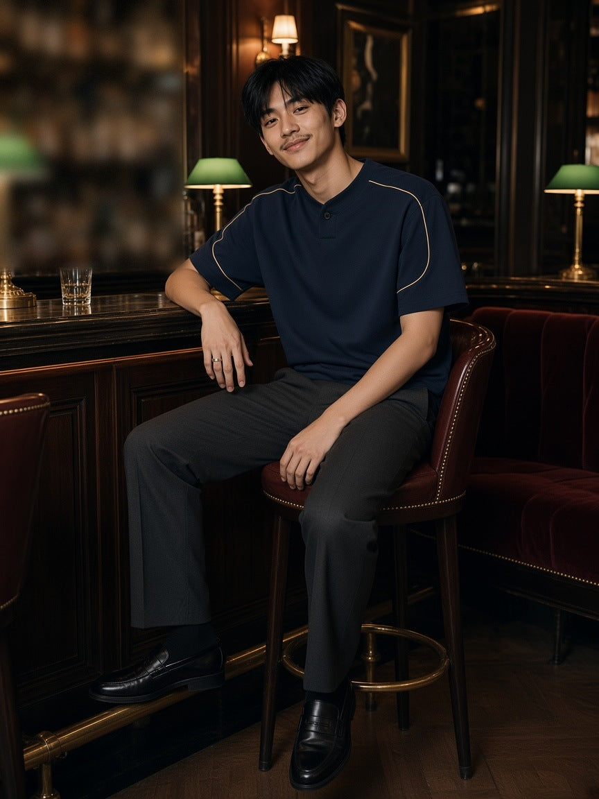 Man in the Oversized Piping Henley T-Shirt in Navy Blue on a stool at a Paris hotel bar at night