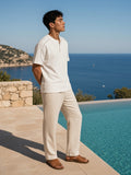 Marcel Afters Oversized Piping Henley T-Shirt in White, worn by a man, standing barefoot by an infinity pool above the sea in a white piped henley