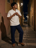 Man in the Oversized Piping Henley T-Shirt in White on a stepped lane in Menton on the Riviera at night