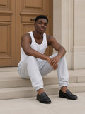 Man in the Men's Heavyweight Fleece Joggers in Flower Gray and a white tank, seated on limestone steps by an oak door in Paris