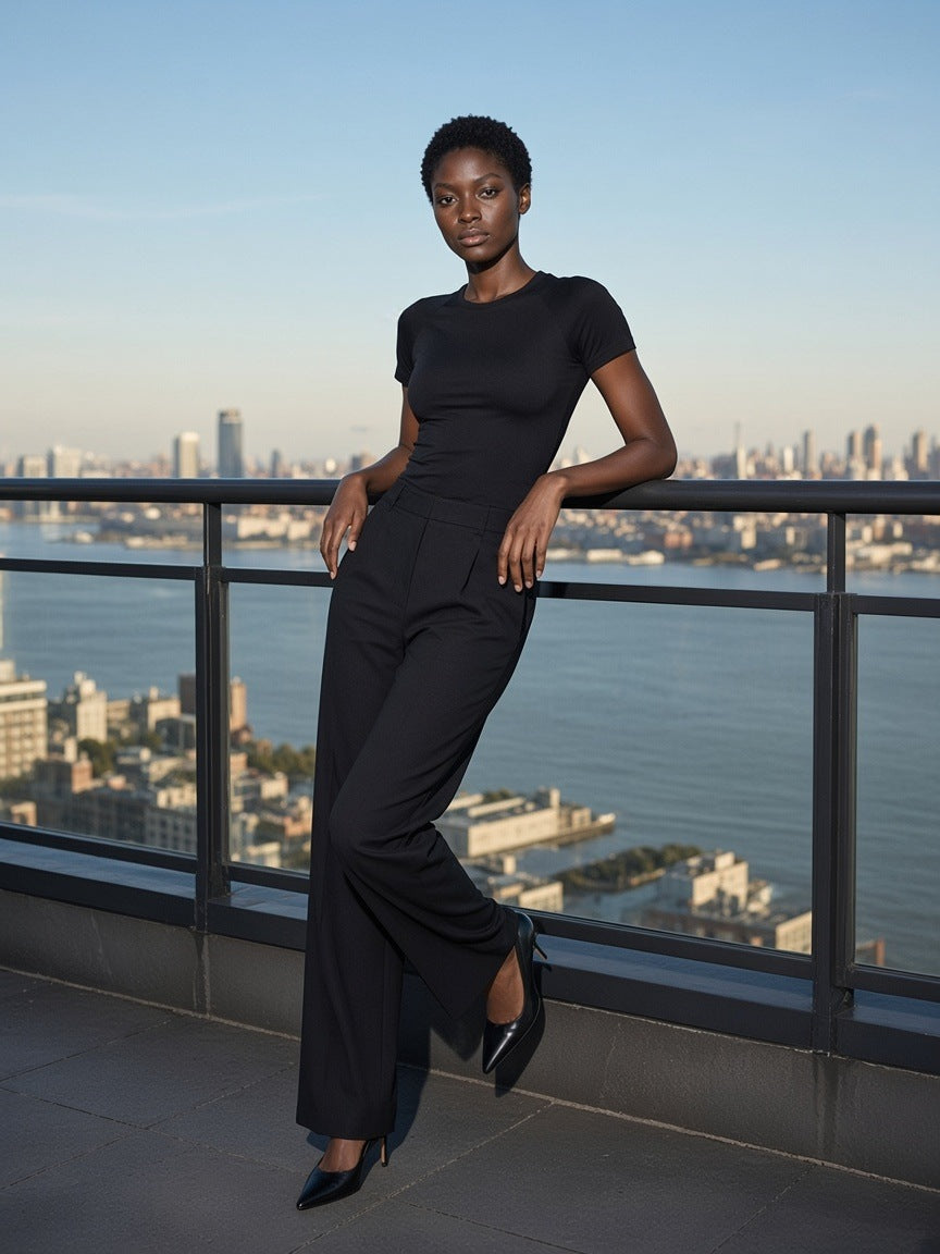 Woman in the Performance Short Sleeve T-Shirt in Black standing on a rooftop above the Hudson in New York by day