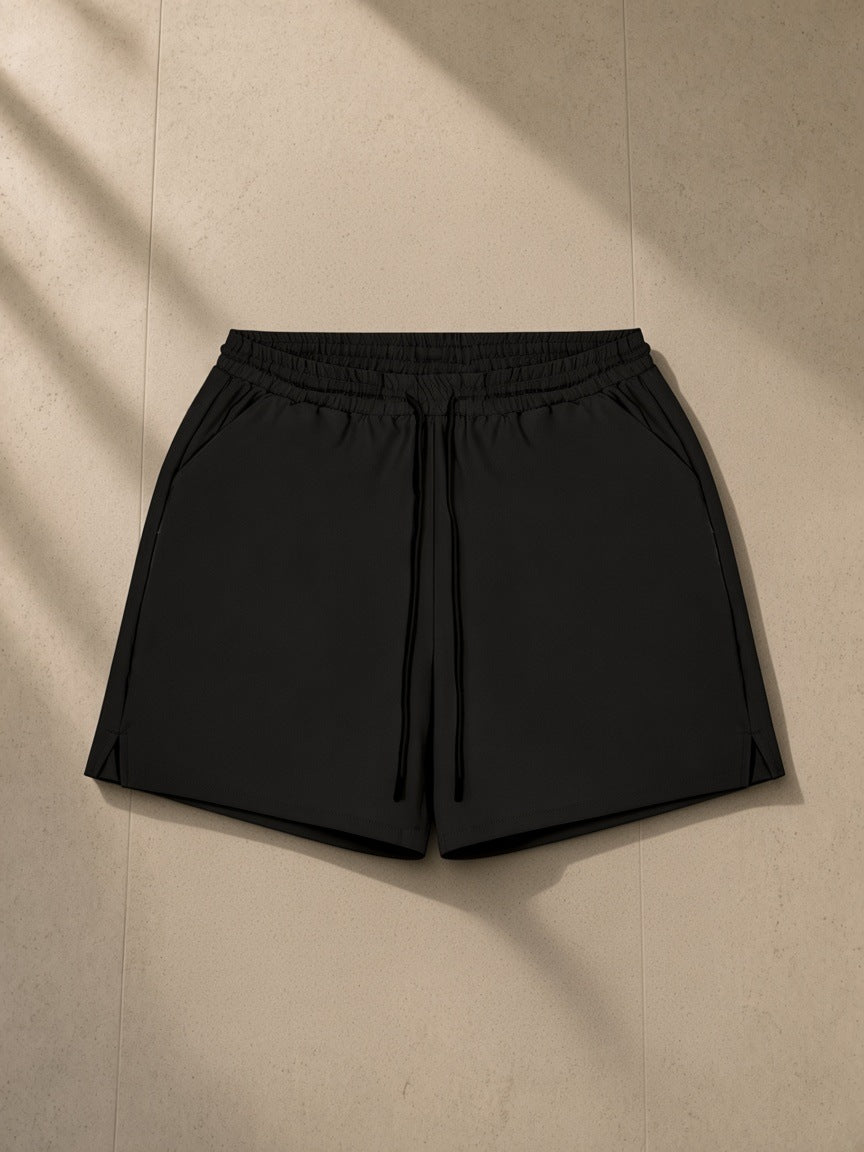 Men's Pocketed Compression-Lined Performance Shorts in Black, laid flat on pale limestone
