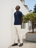 Man in the Quarter-Zip Knit Polo in Navy Blue, looking up at a white gallery facade in Hannam-dong, Seoul in the morning