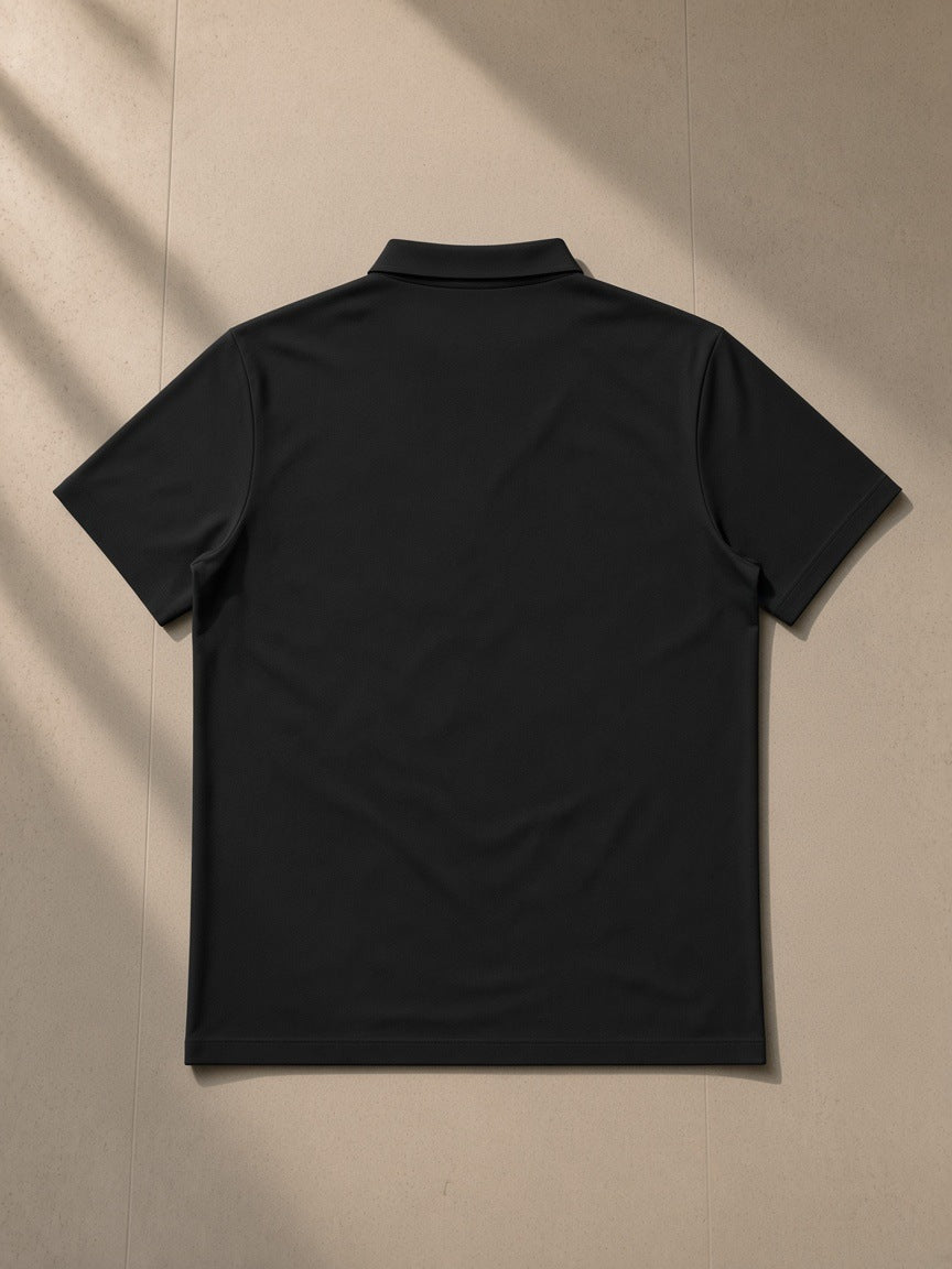 Men's Quarter-Zip Performance Polo Shirt in Black, laid flat on pale limestone, back view