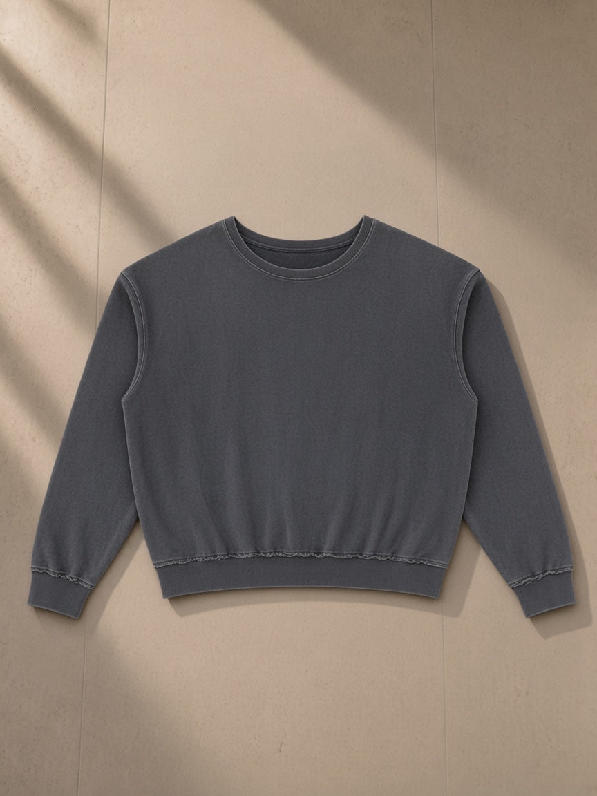 Raw edge crewneck sweatshirt in Washed Gray, laid flat on pale limestone, front view