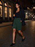 Woman in the Raw Edge Fleece Shorts in Dark Green on a cobbled Tribeca street in New York at night