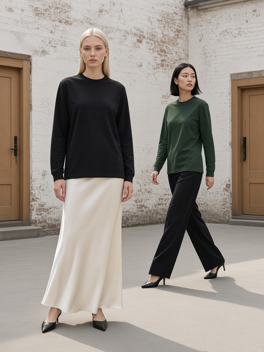 Two people in the Marcel Afters Raw Hem Long Sleeve T-Shirt in Black and Dark Green, in a white-brick courtyard in Copenhagen