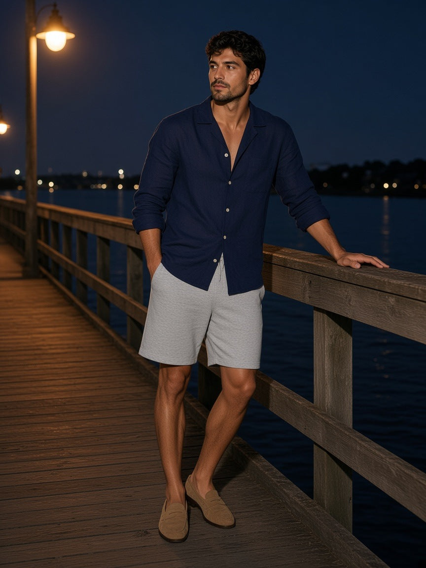 Man in the Marcel Afters Regular Fit Shorts in Flower Gray on a villa dock on Lake Como at night