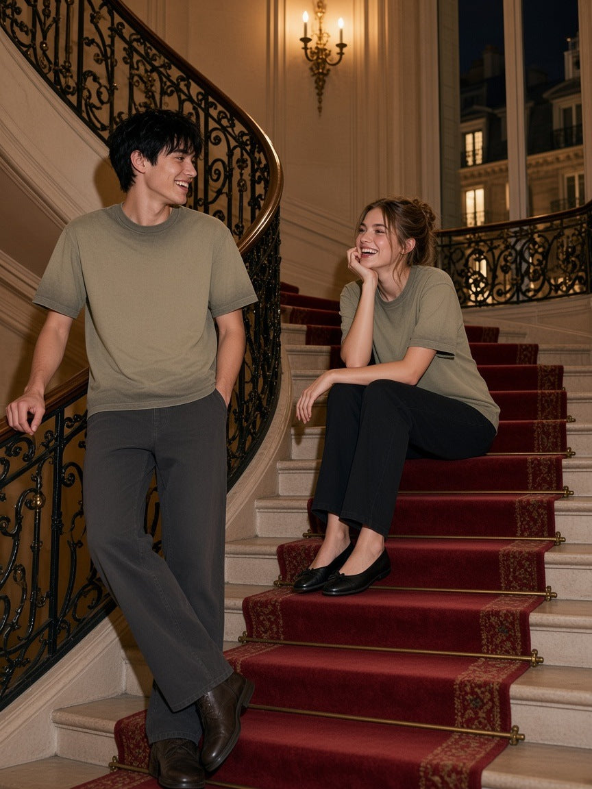 Two people in the Marcel Afters Reverse Dyed Loose Cotton T-Shirt in Green on a Paris Haussmann staircase at night