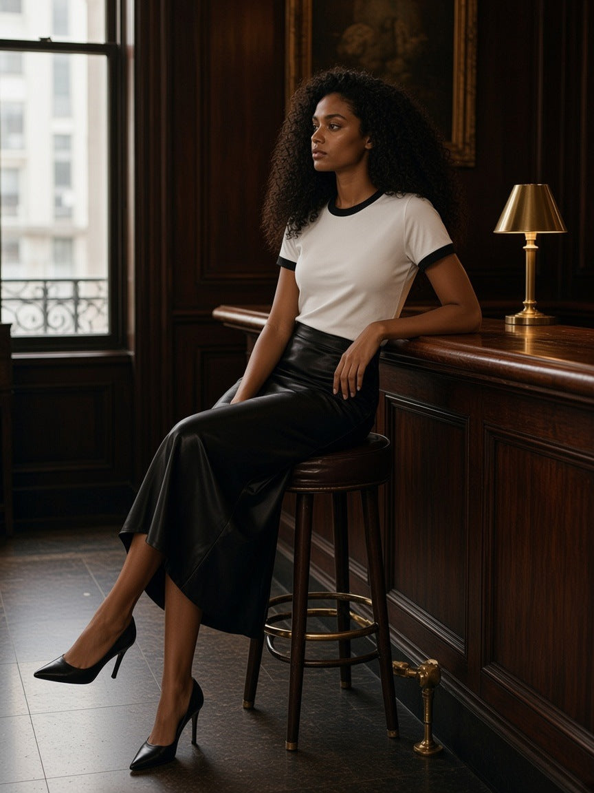 Woman in the Ringer T-Shirt in White with a satin skirt in a hotel bar in New York in the morning