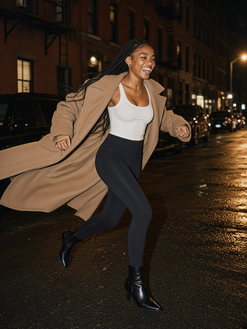 Woman in the Women's High Waisted Ankle Leggings in Black, hopping a puddle on a Brooklyn street at 2am