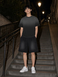 Man in the Black Sunfade set, raw edge tee and raw edge shorts, on the Montmartre stairs at night