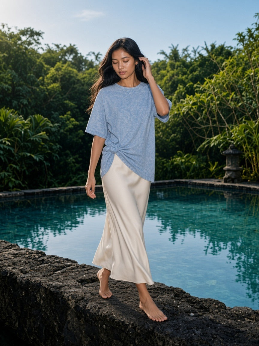 Woman in the Snow Washed Oversized Cotton T-Shirt in Water Blue at a villa pool edge at a resort in Bali in the morning