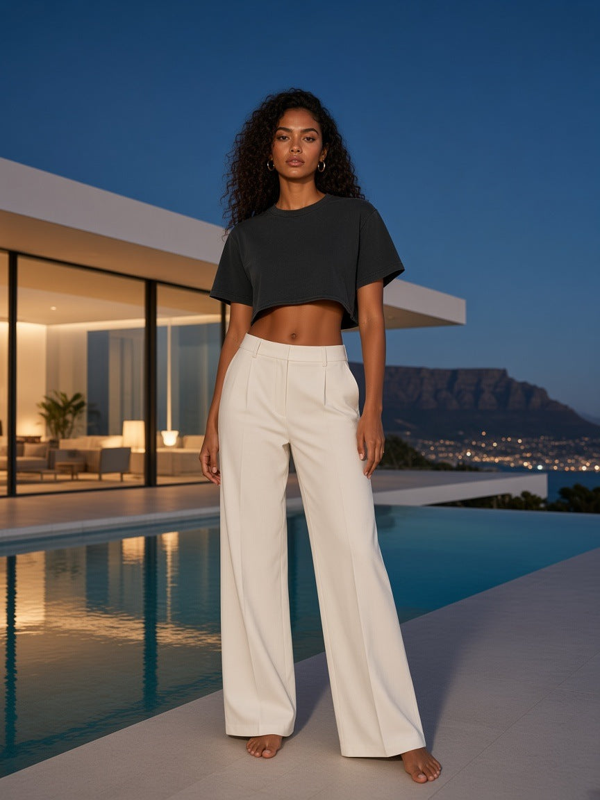 Woman in the Marcel Afters Snow Washed Raw Edge Crop Top in Black, at a villa infinity pool at blue hour in Cape Town