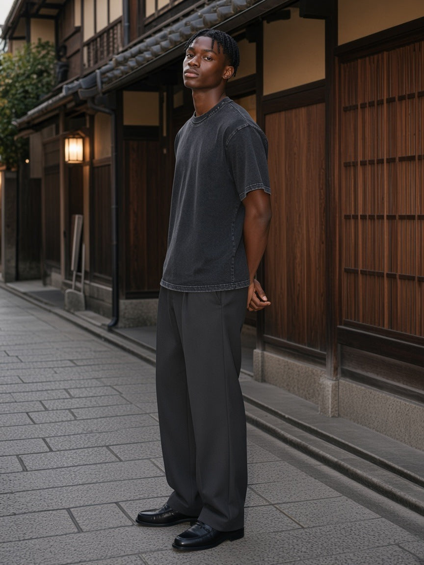 Man in the Snow Washed Raw-Edge Neckline T-Shirt in Black standing in a timber lane in Kyoto in the morning