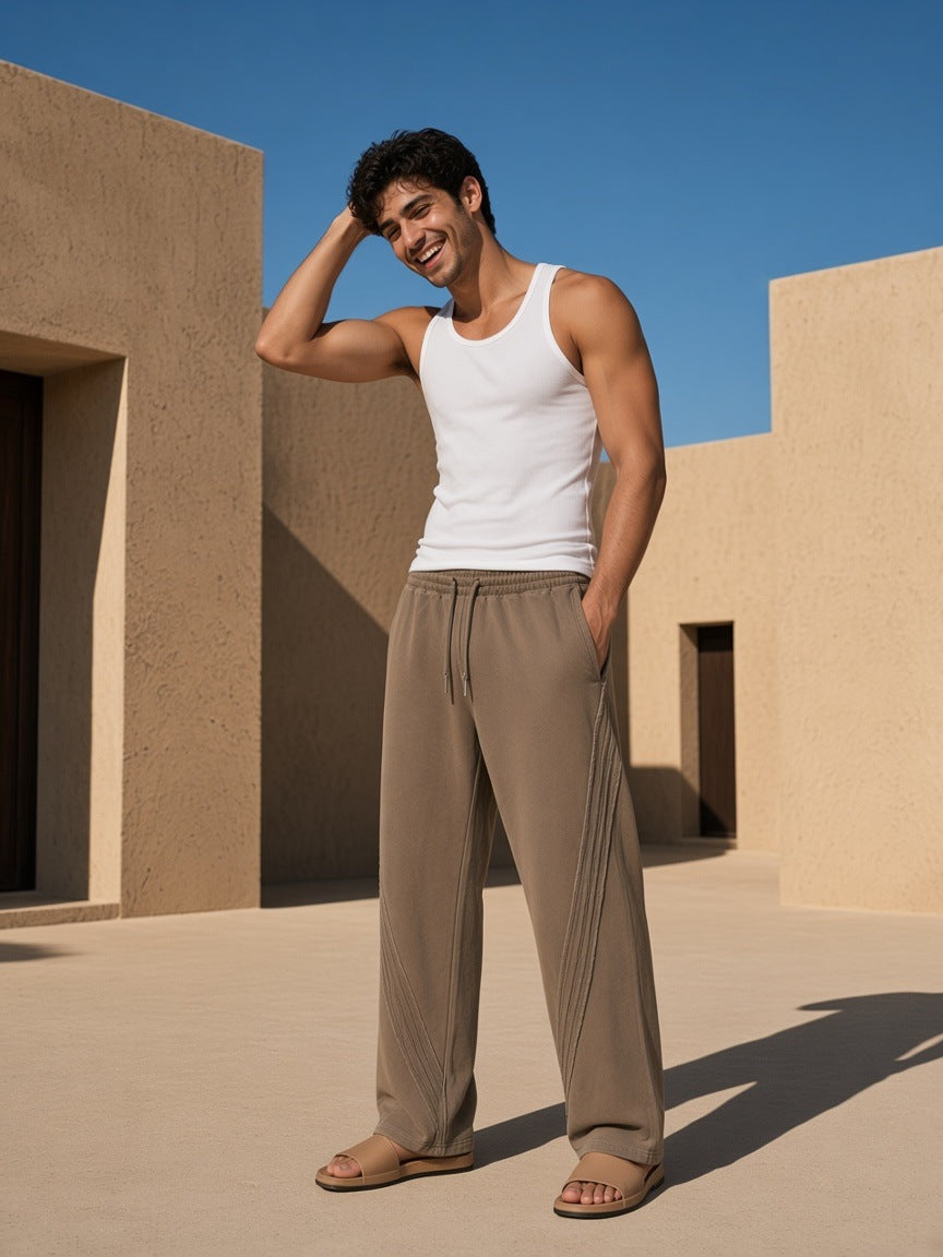Man in the Snow Washed Tape Raw Edge Sweatpants in Khaki, in a desert-resort courtyard in the morning in Utah