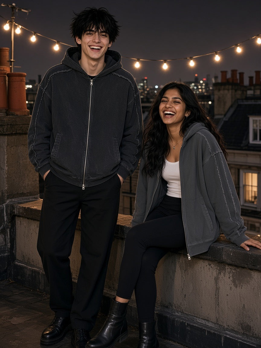 Two people in the Marcel Afters Snow Washed Tape Raw Edge Zip Hoodie in Black and Dark Gray on a London rooftop at night