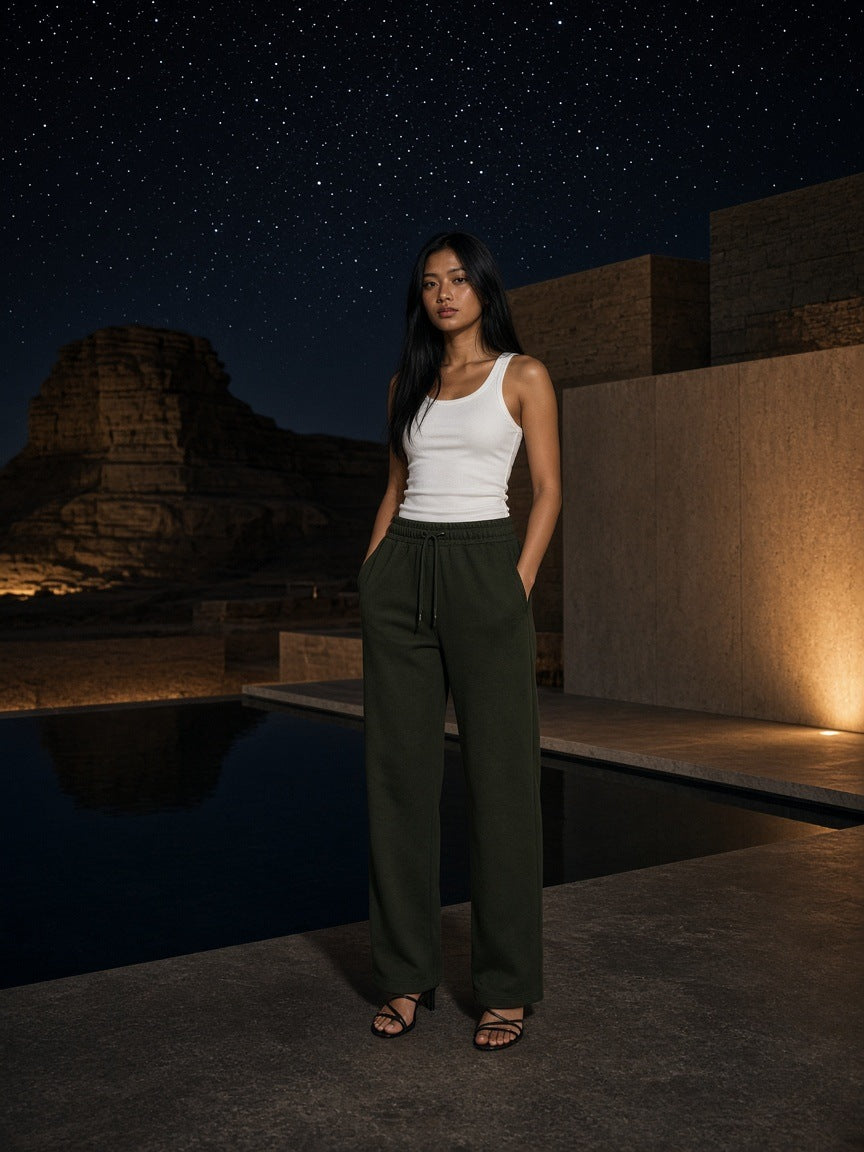 Woman in the Marcel Afters Solid Color Straight-Leg Sweatpants in Blackish Green at a desert resort pool at Amangiri at night