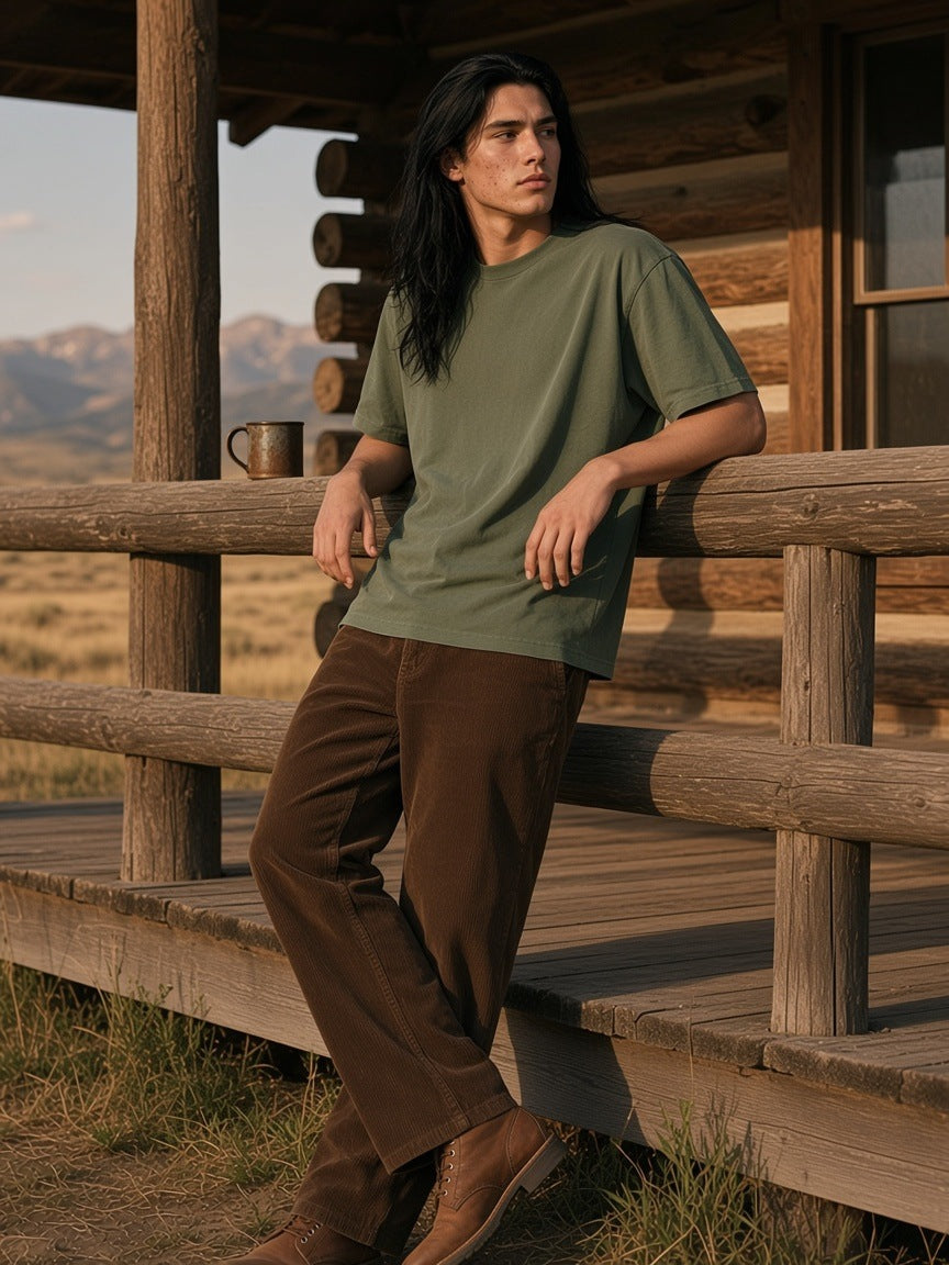 Man in the Sorona Quick-Dry Boxy T-Shirt in Army Green on a ranch lodge porch in Wyoming at golden hour