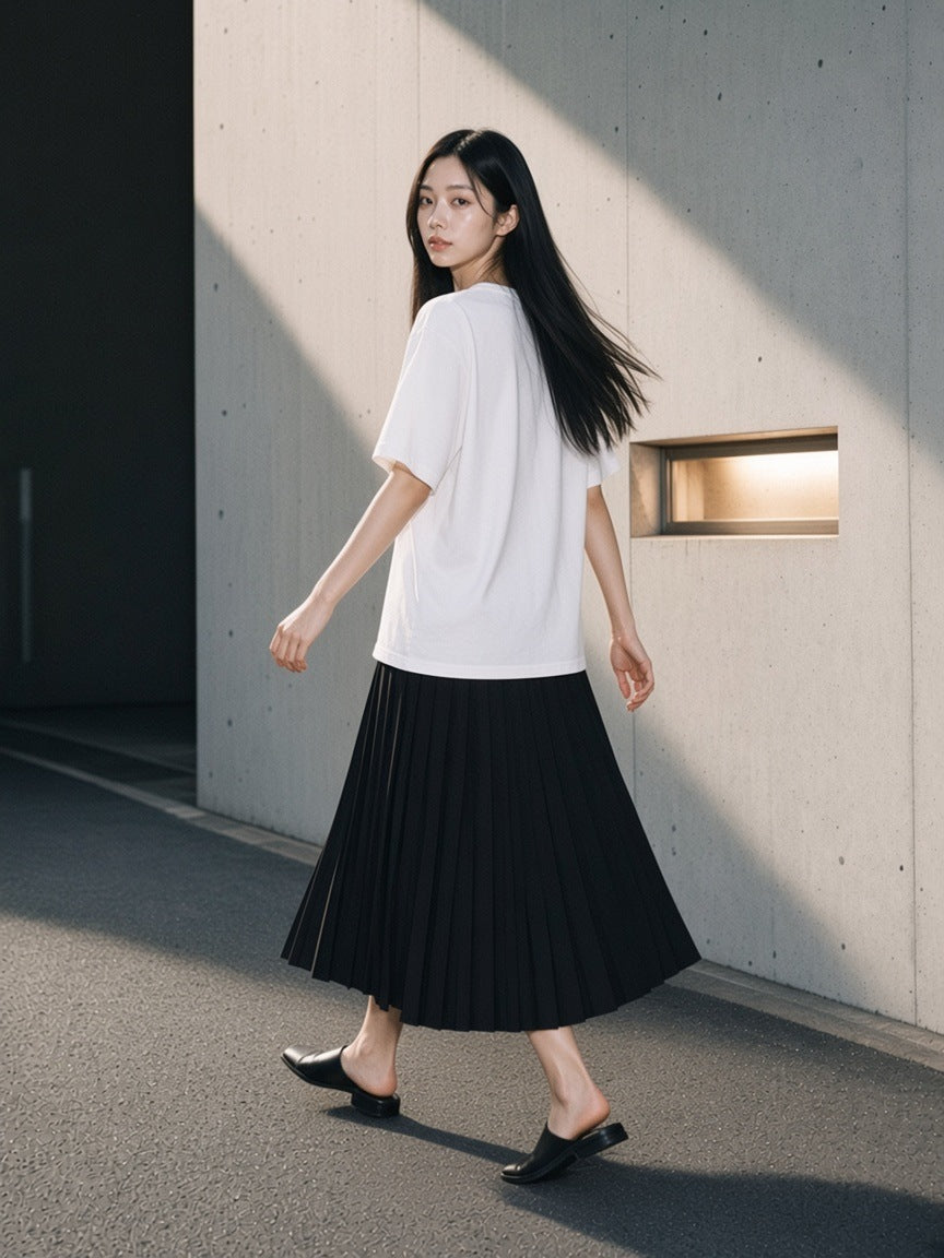Woman in the Sorona Quick-Dry Loose Fit Boxy T-Shirt in White by a concrete wall in Aoyama Tokyo in the morning