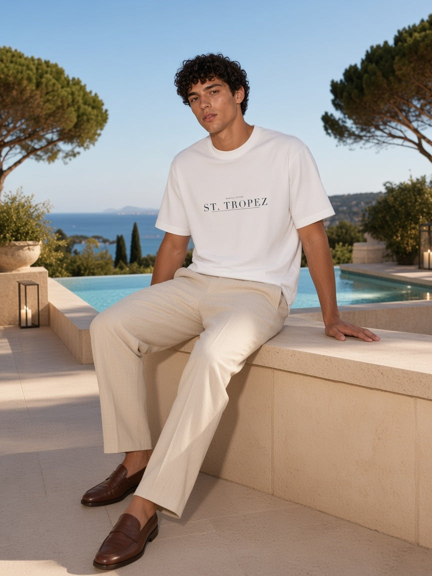 Man in the St. Tropez Heavyweight Drop Shoulder T-Shirt in White on a villa terrace in St. Tropez in the morning