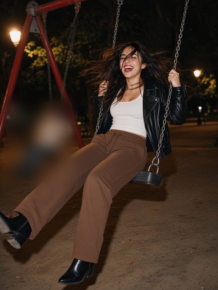 Woman in the Straight Leg Sweatpants in Coffee, swinging high in a Madrid park at 1am