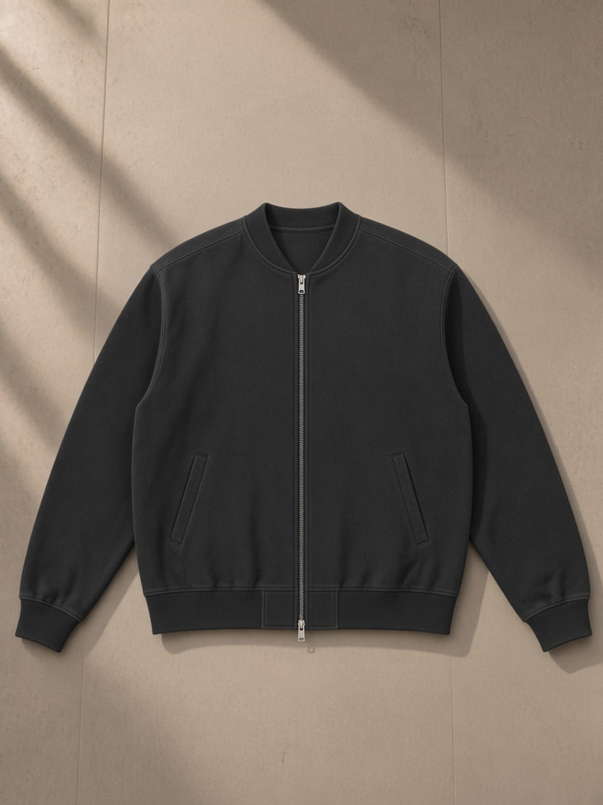 Sun fade heavyweight baseball jacket in Black, laid flat on pale limestone, front view