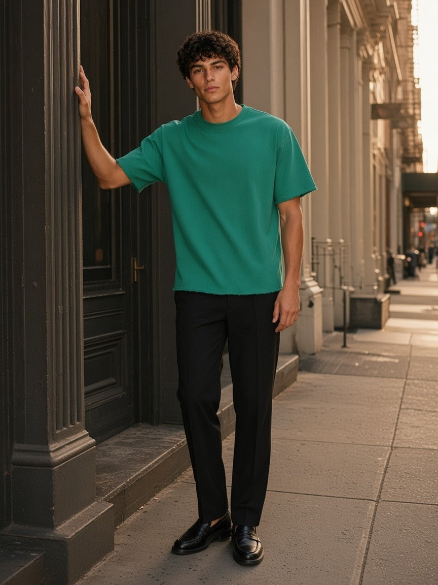 Man in the Sun Fade Raw Edge T-Shirt in Green in a cast-iron doorway on Mercer Street, New York in the morning