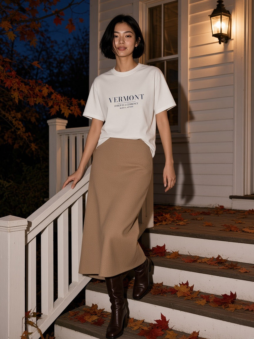 Woman in the Syrup Is A Currency Heavyweight Drop Shoulder T-Shirt in White on a country inn porch in Vermont at night