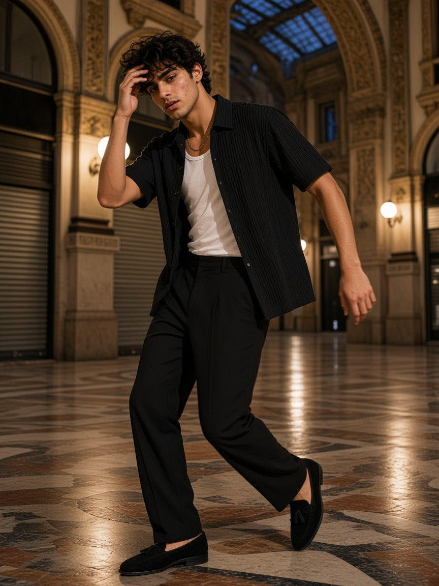 Man in the Tencel Jacquard Shirt in Black, worn open over a white tank, turning on a marble floor in a Milan galleria at night