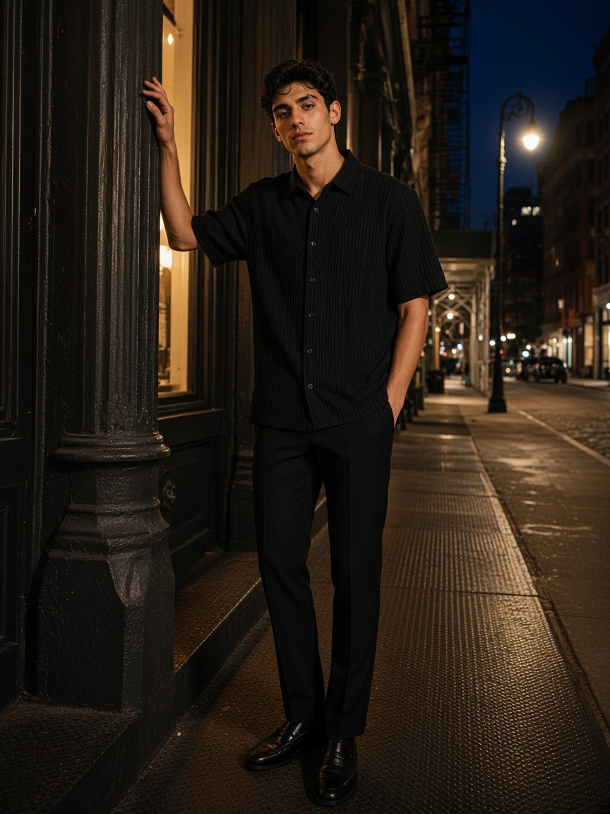 Man in the Tencel Jacquard Shirt in Black, leaning in a cast-iron doorway in SoHo, New York at night