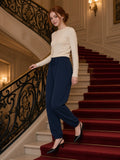 Woman in the Loose Fit Tapered Joggers in Navy Blue coming down a marble hotel staircase in Paris at night