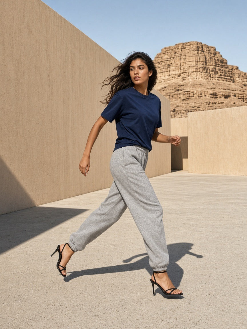 Woman in the Marcel Afters Boxy Coolmax T-Shirt in Navy Blue crossing a desert-modern concrete walkway