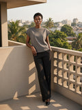 Woman in the Boxy Raw Edge T-Shirt in Gray on a concrete balcony in Lagos in the morning