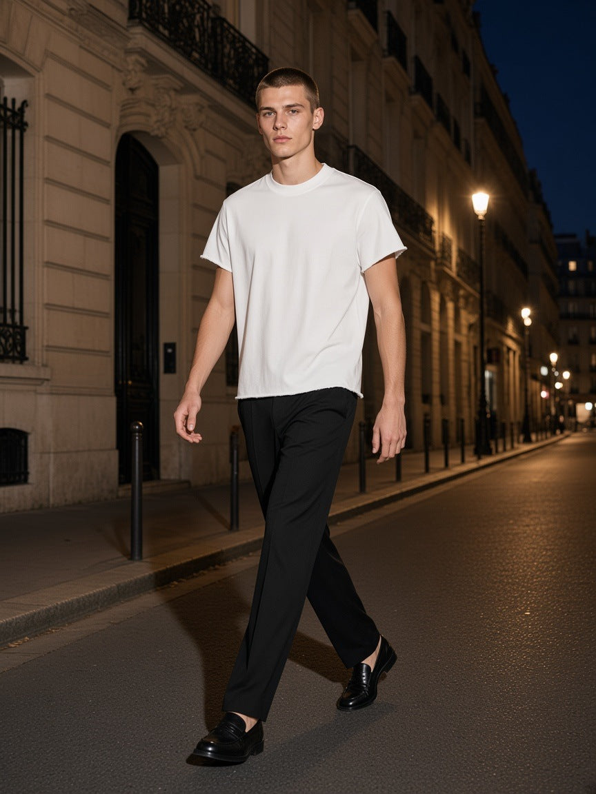 Man in the Boxy Raw Edge T-Shirt in White walking a Haussmann street in Paris at night