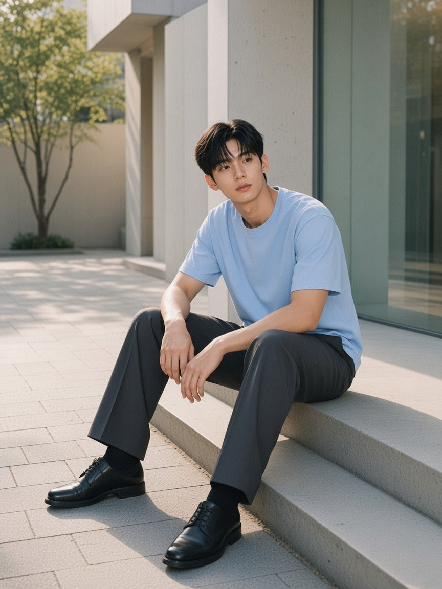 Man in the Drop Shoulder Cotton T-Shirt in Blue sitting on a step on a gallery street in Hannam-dong, Seoul in the morning