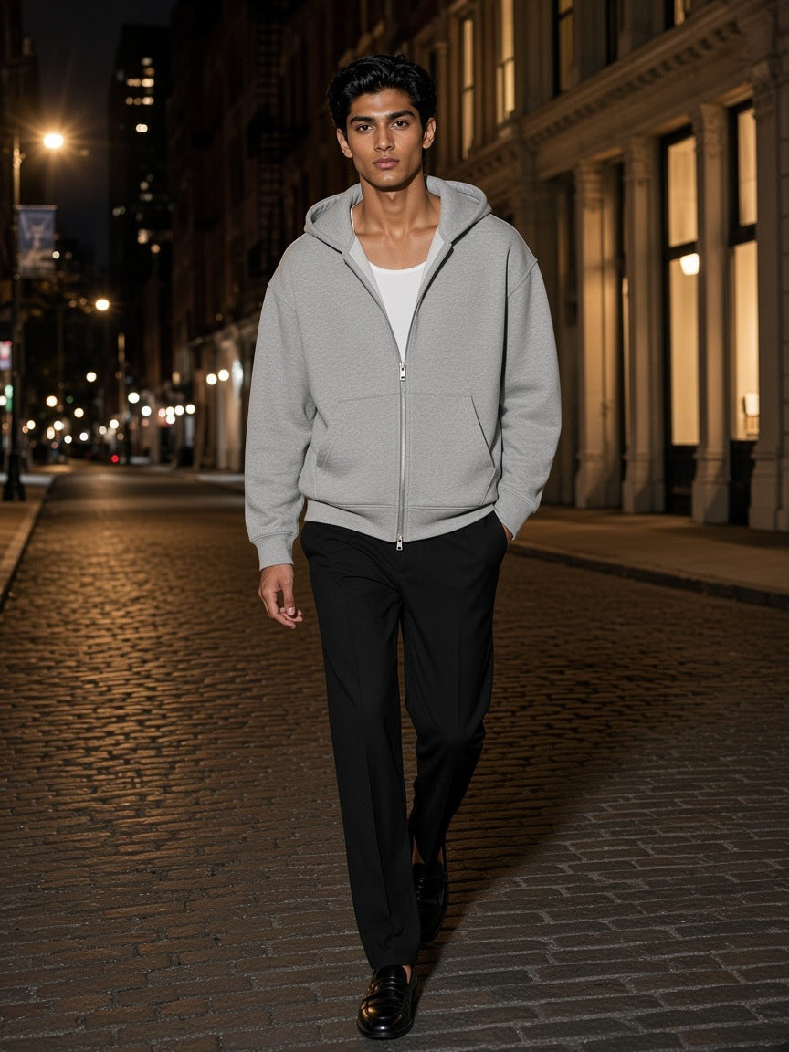 Man in the Drop Shoulder Full Zip Hoodie in Flower Gray walking a cast-iron street in SoHo, New York at night