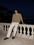 Man in the Heavyweight Boxy Raw Edge T-Shirt in Khaki on a limestone villa terrace on the Cote d'Azur at night