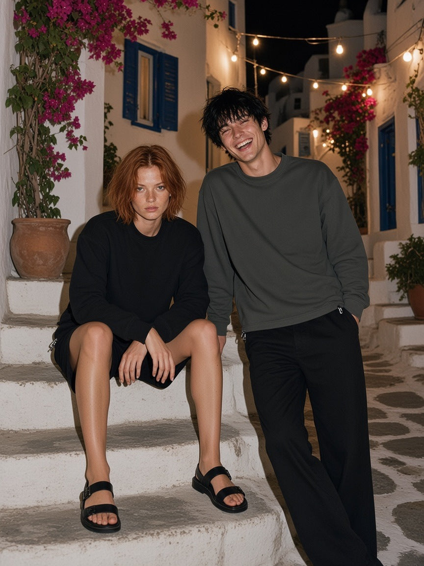Two people in the Heavyweight Oversized Boxy Sweatshirt in Dark Gray and Black on Mykonos steps at night