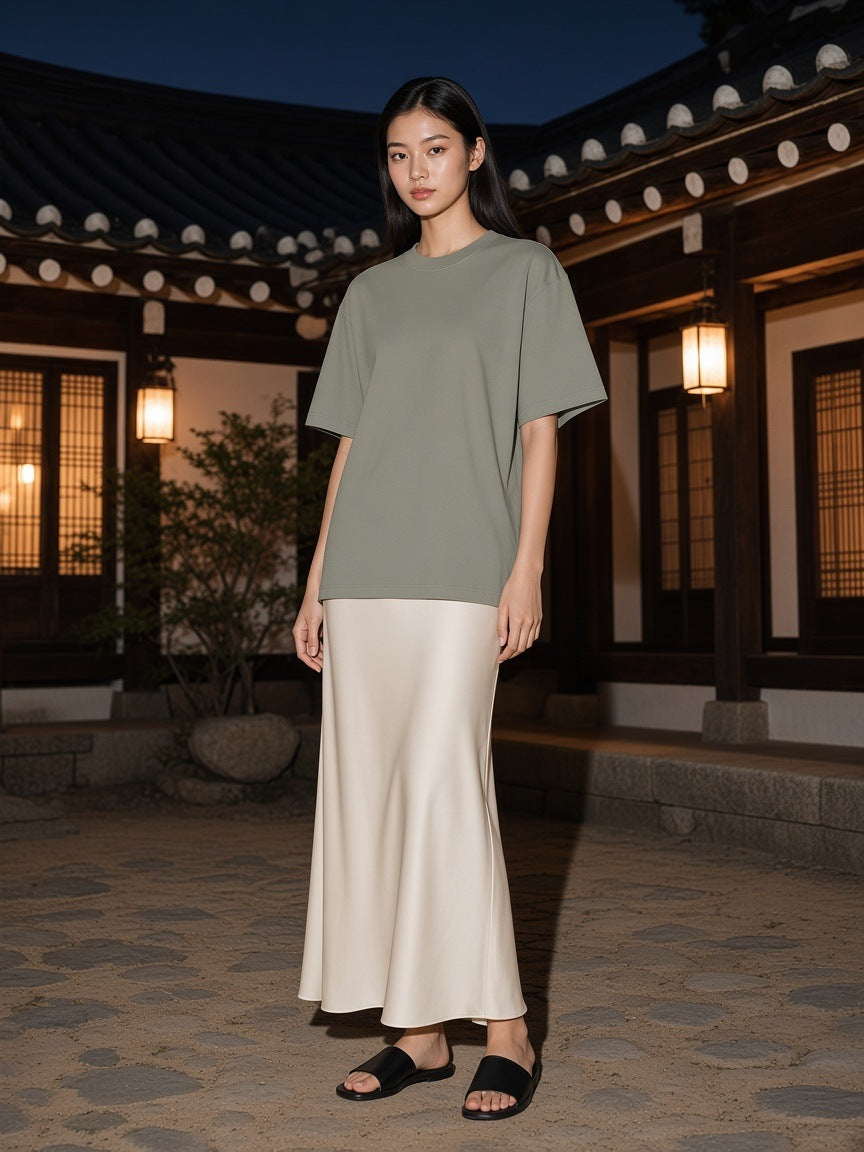 Woman in the Heavyweight Oversized T-Shirt in Gray Green standing in a hanok courtyard in Seoul at night
