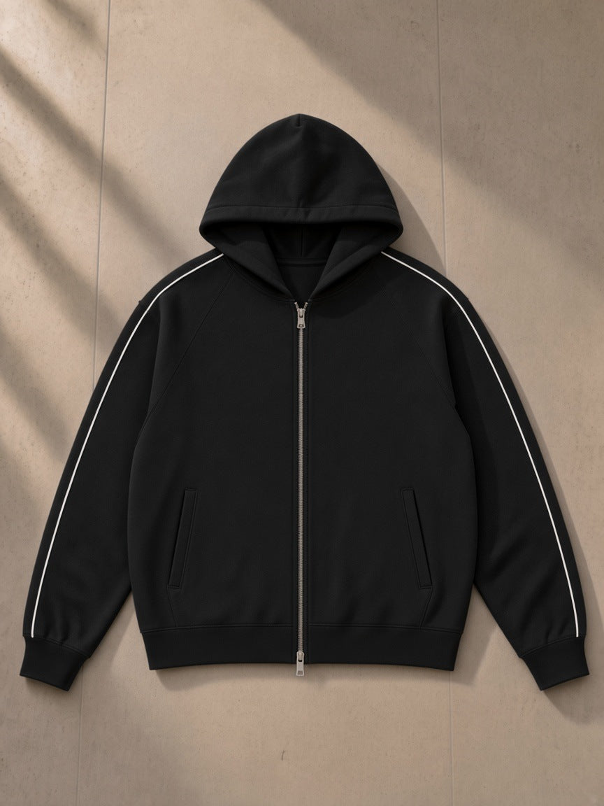 Unisex heavyweight raglan sleeve zip hoodie in Black, laid flat on pale limestone, front view
