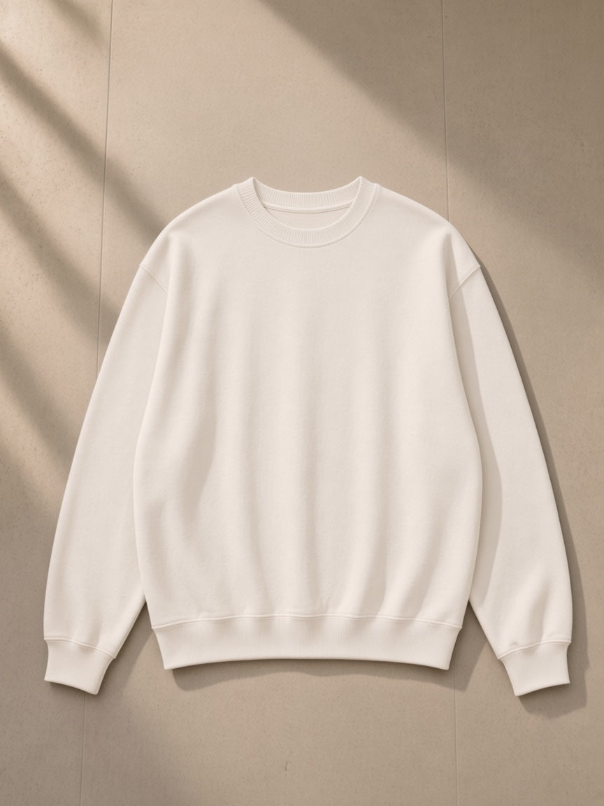 Unisex knitted round neck oversize sweatshirt in White, laid flat on pale limestone, front view