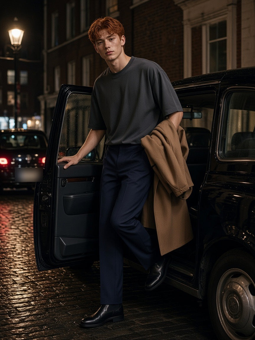 Man in the Lightweight Oversized T-Shirt in Charcoal Gray stepping out of a taxi in a Soho mews in London at night