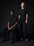 Two people in the Oversized Cotton T-Shirt in Black in a charcoal studio