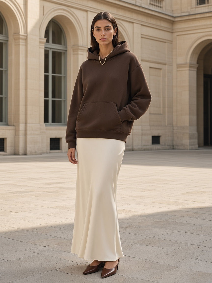 Woman in the Marcel Afters Oversized Heavyweight Hoodie in Coffee, in a pale limestone courtyard in Paris