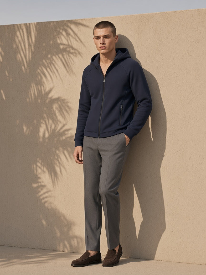 Man in the Paneled Full-Zip Hoodie in Navy Blue, against a sand-toned wall in Marrakech in the morning