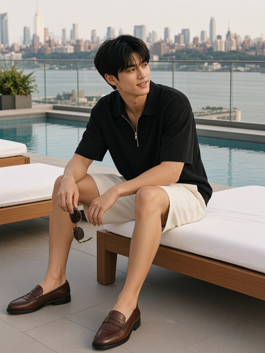 Man in the Quarter-Zip Polo Shirt in Black on the edge of a lounger by a rooftop pool above the Hudson in New York in the morning