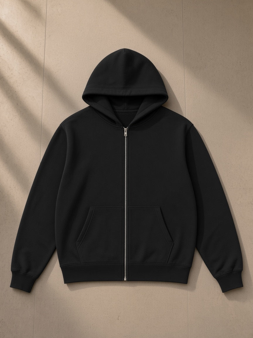 Unisex regular fit full zip hoodie in Black, laid flat on pale limestone, front view