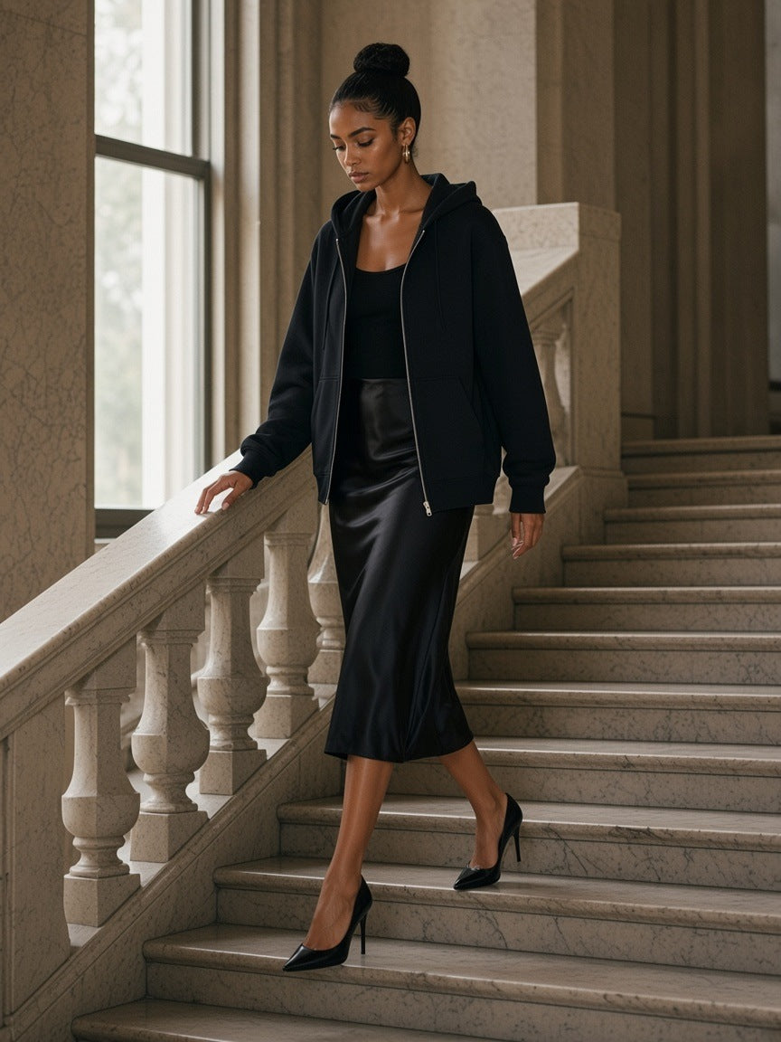 Woman in the Regular Fit Full-Zip Hoodie in Black, coming down the staircase of a marble hotel lobby in the morning in Milan