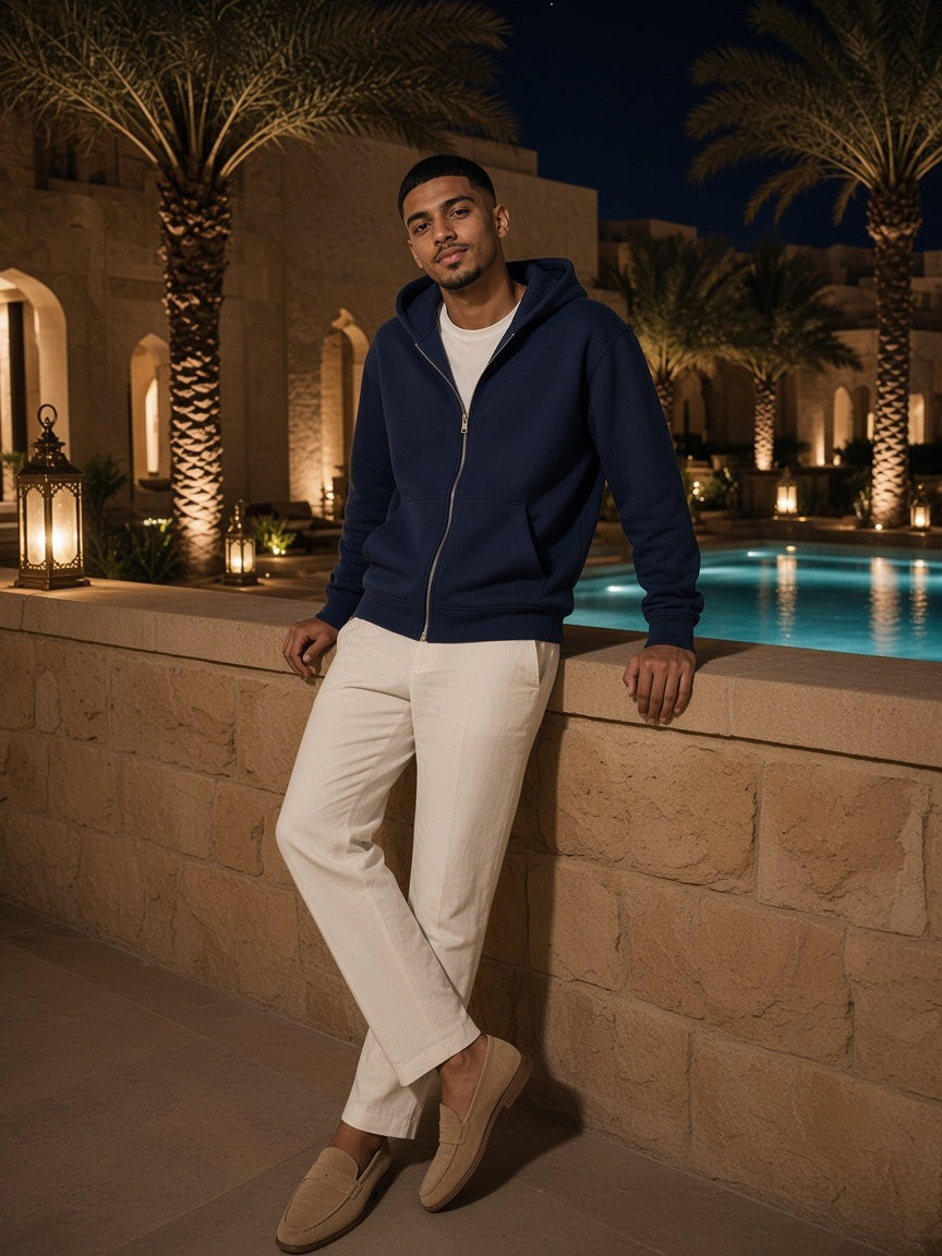 Man in the Marcel Afters Regular Fit Full-Zip Hoodie in Navy Blue, in a desert-resort courtyard at night in Dubai